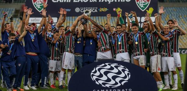 Os jogadores ligam e os médicos do clube levantam o troféu para o pódio